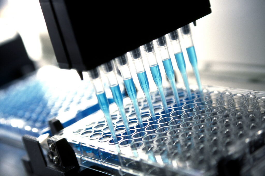 Robotic multichannel pipette dispensing blue liquid for pharmaceutical research and testing.